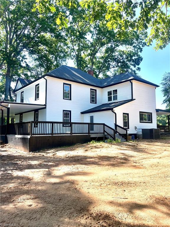 937 Haynes Rd, Summerfield, NC 27358 - back of property featuring a wooden deck and a chimney