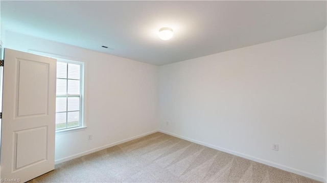 unfurnished room featuring light colored carpet