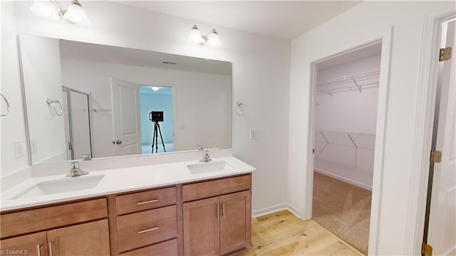 bathroom featuring vanity, an enclosed shower, and wood-type flooring