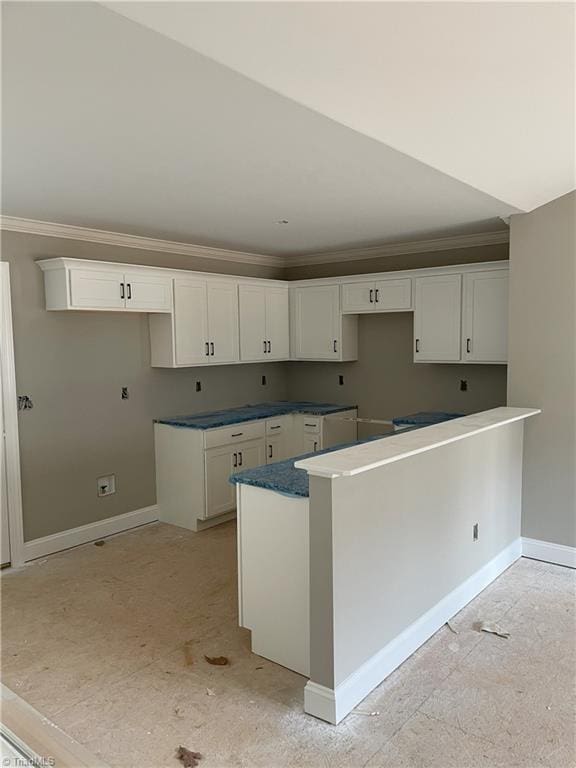 kitchen with white cabinets, kitchen peninsula, and crown molding