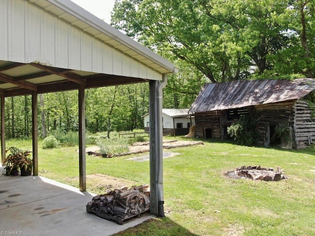 431 Needham Rd, Pilot Mountain, NC 27041 - view of green lawn with a fire pit, an outdoor structure, and a patio area