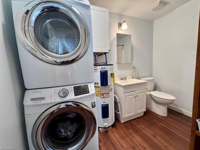 431 Needham Rd, Pilot Mountain, NC 27041 - laundry room with stacked washer / dryer, electric water heater, and dark wood-style flooring