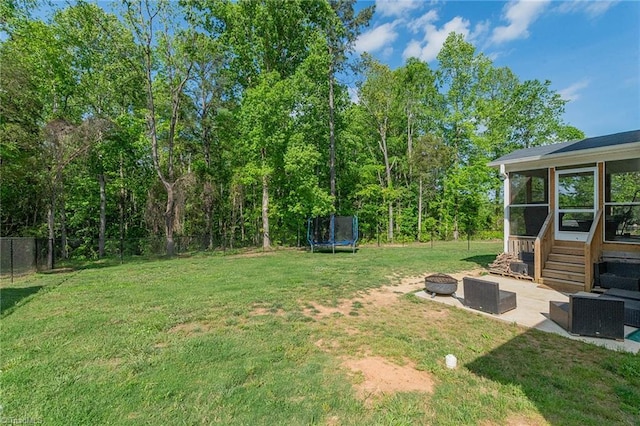 1765 Midway School Rd, Winston-Salem, NC 27107 - view of yard with fence, a trampoline, a patio area, a sunroom, and a fire pit
