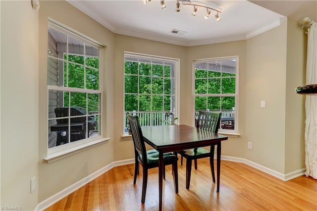dining area featuring crown molding, baseboards, wood finished floors, and visible vents