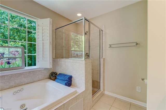 bathroom featuring a stall shower, a bath, tile patterned floors, and a wealth of natural light