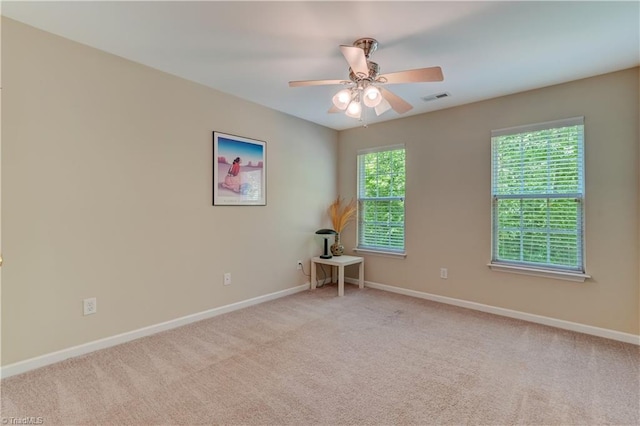 empty room with a ceiling fan, baseboards, visible vents, and carpet