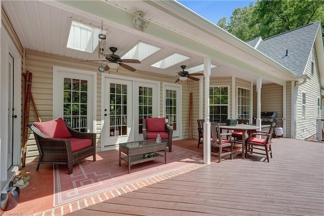 deck with french doors, outdoor dining area, and ceiling fan