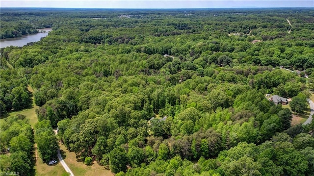 drone / aerial view featuring a water view and a forest view