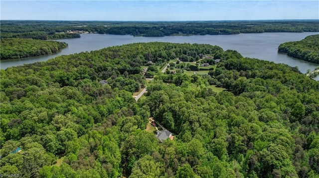 drone / aerial view featuring a water view and a wooded view