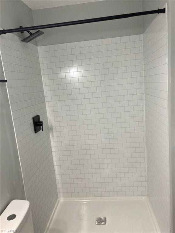 full bathroom featuring toilet and a shower stall