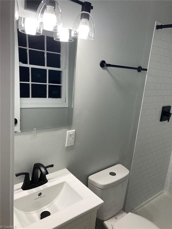 bathroom with vanity, a shower stall, and toilet