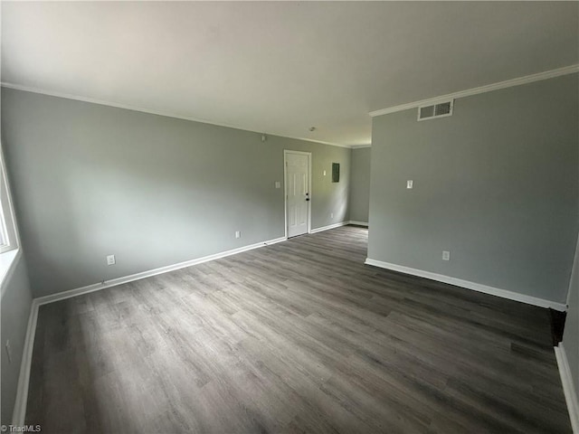unfurnished room featuring visible vents, ornamental molding, dark wood-style flooring, and baseboards