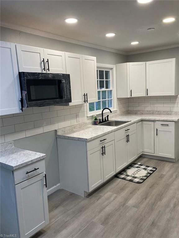 kitchen with crown molding, a sink, and backsplash
