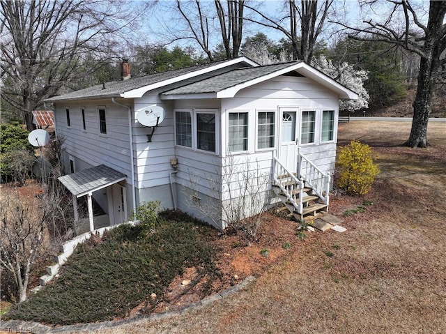 exterior space featuring entry steps and a chimney