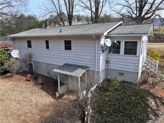 view of property exterior featuring crawl space, a chimney, and roof with shingles