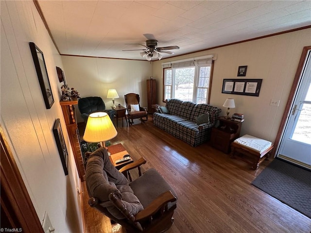 living area with ornamental molding, ceiling fan, and wood finished floors