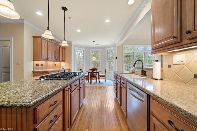 kitchen featuring brown cabinetry, stone counters, stainless steel appliances, and crown molding