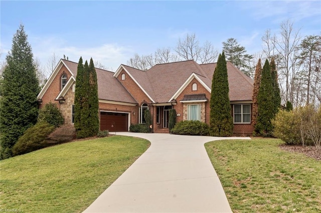 view of front of home with brick siding, driveway, an attached garage, and a front lawn