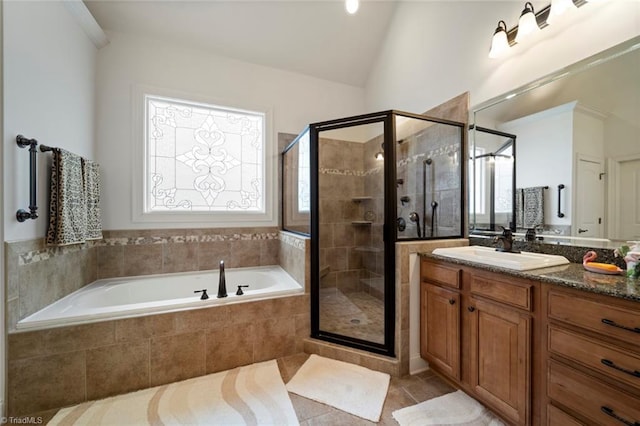 bathroom featuring tile patterned flooring, lofted ceiling, a stall shower, a bath, and vanity