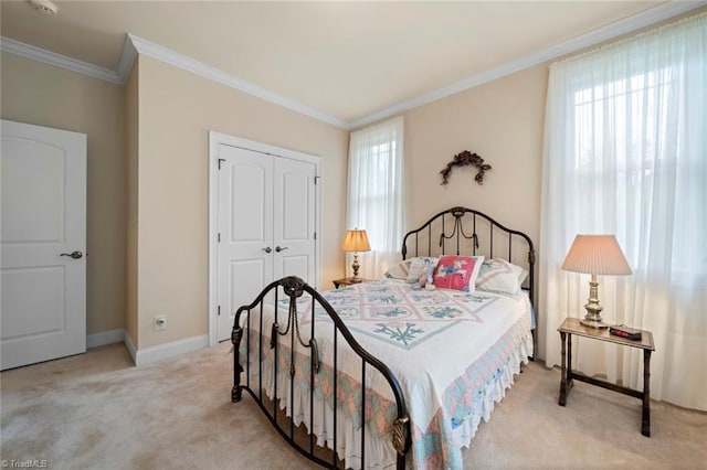 bedroom featuring a closet, baseboards, carpet, and ornamental molding