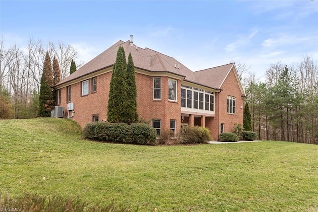 view of side of property with brick siding and a yard