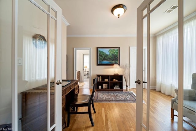 foyer entrance featuring light wood finished floors, visible vents, french doors, and crown molding