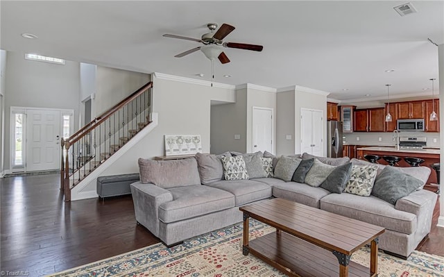 living room with crown molding, ceiling fan, dark wood-type flooring, and sink