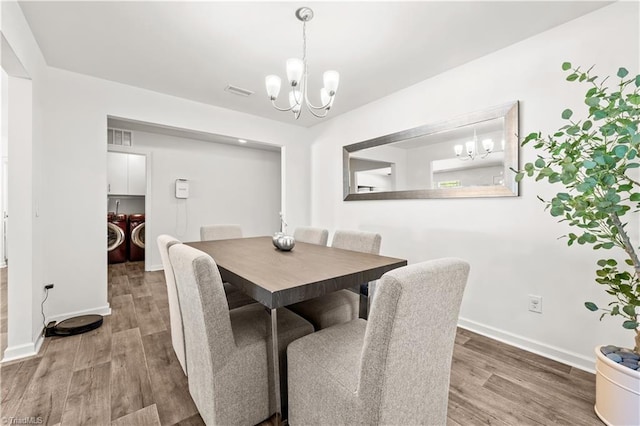 574 Freeport Ct, Winston-Salem, NC 27127 - dining room featuring a chandelier, separate washer and dryer, and wood finished floors