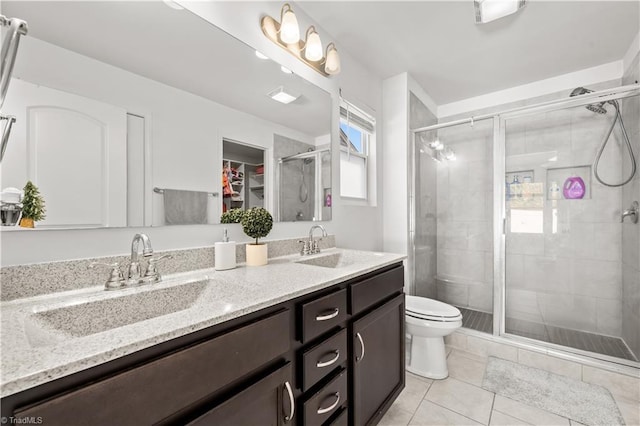 574 Freeport Ct, Winston-Salem, NC 27127 - full bathroom featuring tile patterned flooring, double vanity, a shower stall, toilet, and a walk in closet