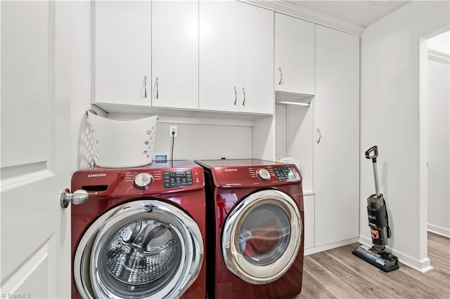 574 Freeport Ct, Winston-Salem, NC 27127 - washroom with washing machine and dryer, light wood-type flooring, cabinet space, and baseboards