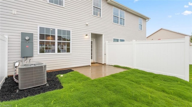 back of property featuring a lawn and central air condition unit