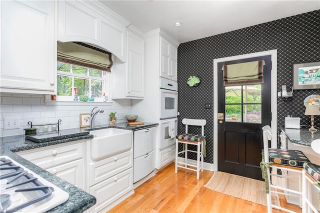 kitchen with plenty of natural light, a sink, dishwasher, and white cabinets