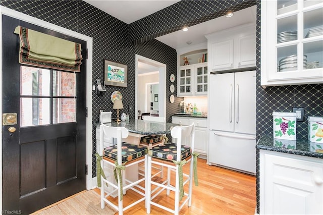 kitchen featuring glass insert cabinets, decorative backsplash, white cabinets, and freestanding refrigerator