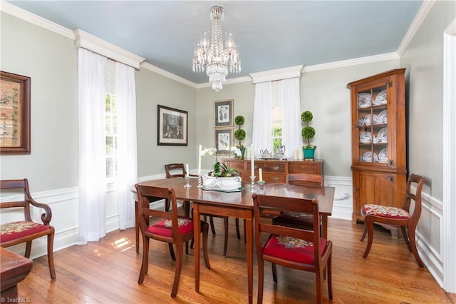 dining room featuring a healthy amount of sunlight, crown molding, and wood finished floors