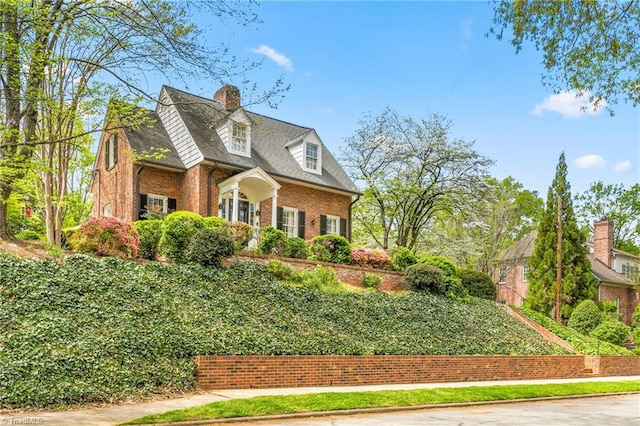 view of property exterior featuring a chimney and brick siding