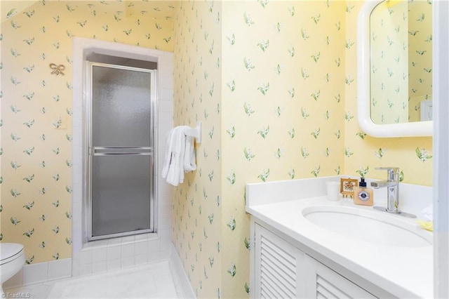 bathroom with vanity, a stall shower, wallpapered walls, and toilet