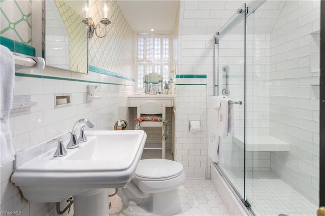 full bath with tile walls, tile patterned flooring, a shower stall, a sink, and toilet