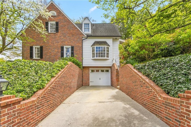 traditional-style home featuring brick siding, driveway, and a garage