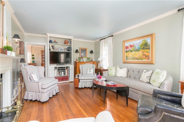 living area with ornamental molding, wood finished floors, and a fireplace