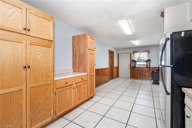 3753 Konnoak Dr SW, Winston-Salem, NC 27127 - kitchen with freestanding refrigerator, wainscoting, a textured ceiling, wooden walls, and light countertops