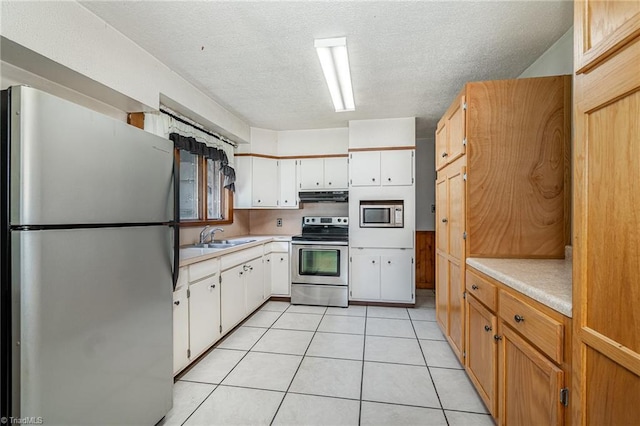 3753 Konnoak Dr SW, Winston-Salem, NC 27127 - kitchen with stainless steel appliances, under cabinet range hood, light countertops, a textured ceiling, and light tile patterned floors