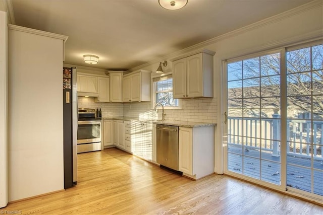 kitchen with backsplash, sink, light hardwood / wood-style floors, and appliances with stainless steel finishes