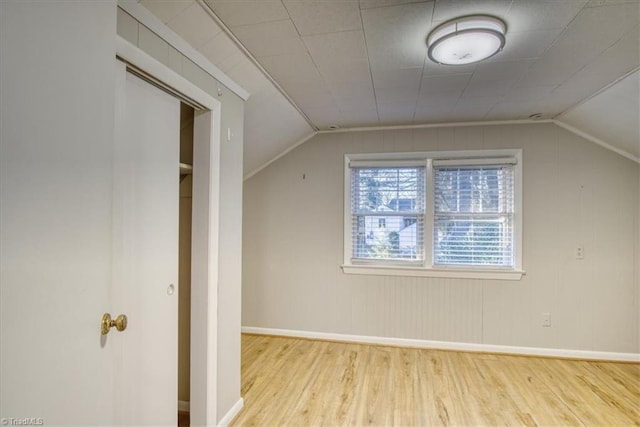 bonus room with light wood-type flooring and lofted ceiling