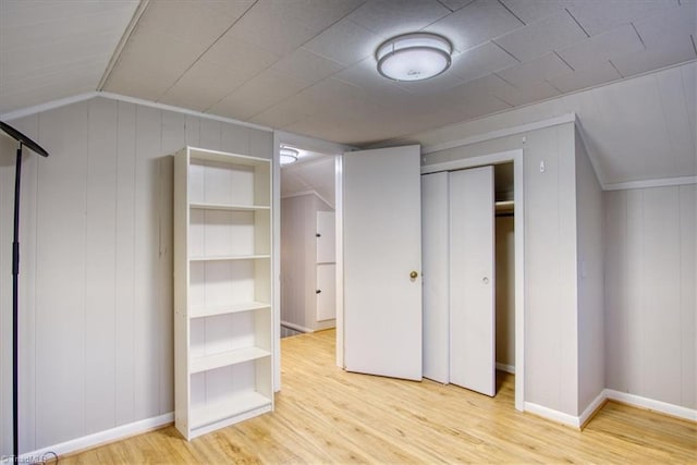 interior space with ornamental molding, light hardwood / wood-style flooring, a closet, and lofted ceiling