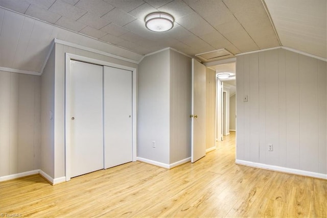 additional living space with light hardwood / wood-style floors and lofted ceiling