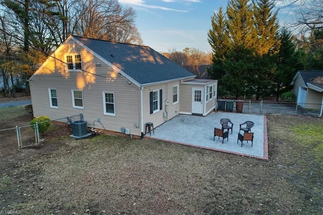 rear view of house with a yard, cooling unit, and a patio area