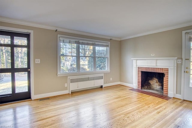 unfurnished living room with a fireplace, light hardwood / wood-style flooring, radiator, and ornamental molding