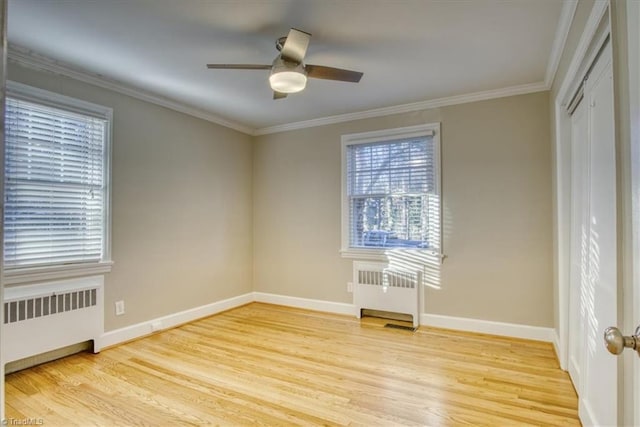 empty room with ceiling fan, radiator heating unit, crown molding, and light hardwood / wood-style flooring