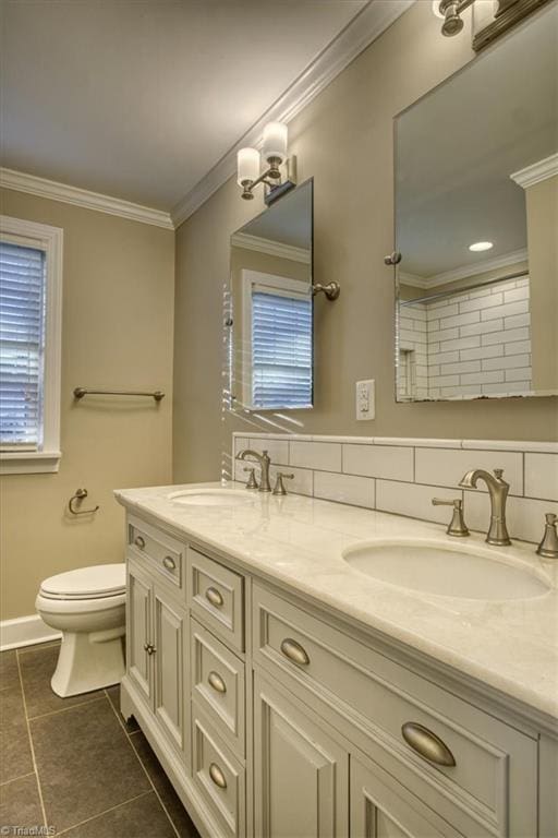 bathroom with toilet, vanity, tile patterned floors, and ornamental molding