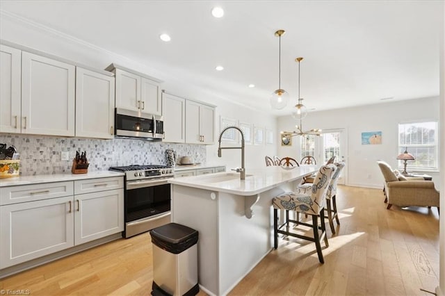 755 Gibb St, Winston-Salem, NC 27106 - kitchen with appliances with stainless steel finishes, a breakfast bar, a sink, decorative backsplash, and light countertops